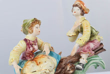 Load image into Gallery viewer, Capodimonte Porcelain Figurine – Boy and Girl Playing See-Saw on Log