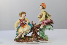 Load image into Gallery viewer, Capodimonte Porcelain Figurine – Boy and Girl Playing See-Saw on Log