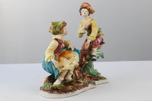 Load image into Gallery viewer, Capodimonte Porcelain Figurine – Boy and Girl Playing See-Saw on Log