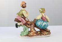 Load image into Gallery viewer, Capodimonte Porcelain Figurine – Boy and Girl Playing See-Saw on Log