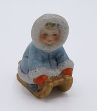 Load image into Gallery viewer, Goebel W. Germany Porcelain Figurine – Child in Blue Parka on Wooden Sled, Winter Scene
