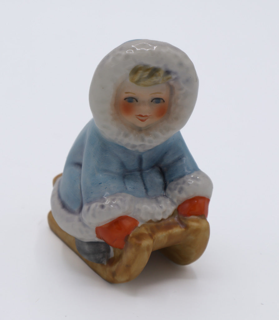 Goebel W. Germany Porcelain Figurine – Child in Blue Parka on Wooden Sled, Winter Scene