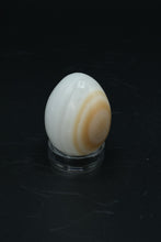 Load image into Gallery viewer, Polished Onyx Stone Egg with Stand – Natural Cream &amp; Amber Tones
