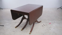 Load and play video in Gallery viewer, Vintage Mahogany Drop Leaf Dining Table with Triple Pedestal Brass Capped Base

