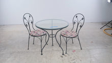 Load and play video in Gallery viewer, Wrought Iron Glass Top Bistro Table and Two Floral Side Chairs
